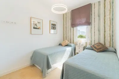 a bedroom with two beds and a window at Lujoso chalet con jardín privado a 300 metros de la playa in Conil de la Frontera