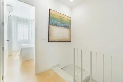 a white hallway with a painting on the wall at Lujoso chalet con jardín privado a 300 metros de la playa in Conil de la Frontera