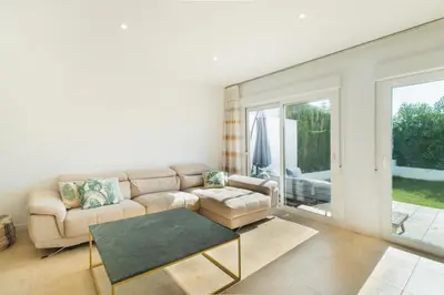 a living room with a couch and a table at Lujoso chalet con jardín privado a 300 metros de la playa in Conil de la Frontera
