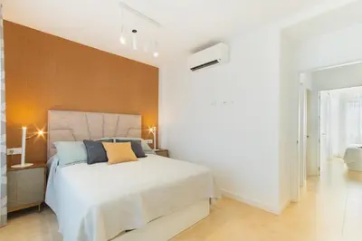 a bedroom with a large white bed with blue pillows at Lujoso chalet con jardín privado a 300 metros de la playa in Conil de la Frontera