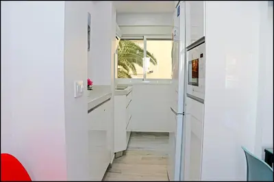 a hallway with white walls and a window at Apartamento Del Rio Playa in Cádiz