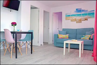 a living room with a blue couch and a table at Apartamento Del Rio Playa in Cádiz