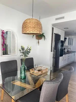 a dining room with a glass table and chairs at Chalet Familiar NUEVO-10min Cádiz Capital in Puerto Real