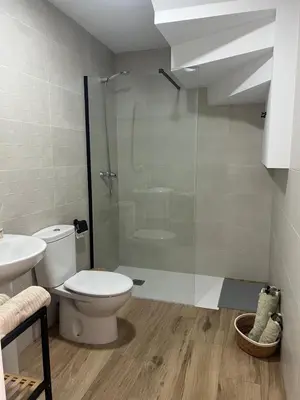 a bathroom with a toilet and a glass shower at Chalet Familiar NUEVO-10min Cádiz Capital in Puerto Real
