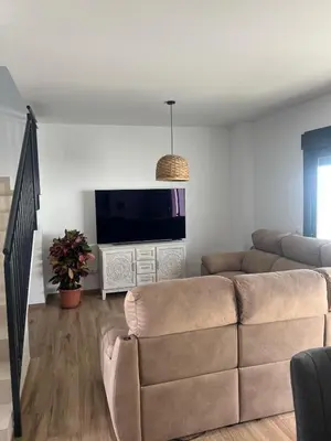 a living room with a couch and a flat screen tv at Chalet Familiar NUEVO-10min Cádiz Capital in Puerto Real