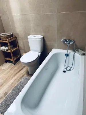 a bathroom with a white bath tub and a toilet at Chalet Familiar NUEVO-10min Cádiz Capital in Puerto Real