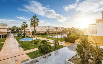 a view of a courtyard with palm trees and a building at Family Oasis in Chipiona - Pool - Terrace - Padel in Cádiz