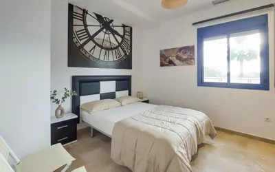 a bedroom with a bed and a large clock on the wall at Family Oasis in Chipiona - Pool - Terrace - Padel in Cádiz