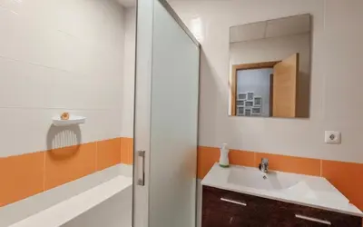 a bathroom with a sink and a shower with a mirror at Family Oasis in Chipiona - Pool - Terrace - Padel in Cádiz