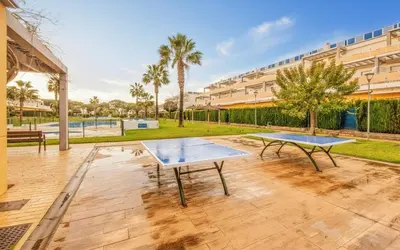 two ping pong tables in a courtyard with a building at Family Oasis in Chipiona - Pool - Terrace - Padel in Cádiz