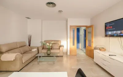 a living room with a couch and a tv at Family Oasis in Chipiona - Pool - Terrace - Padel in Cádiz