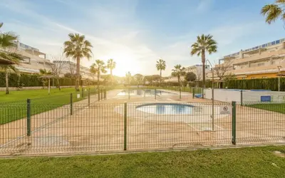 a tennis court in a park with palm trees at Family Oasis in Chipiona - Pool - Terrace - Padel in Cádiz