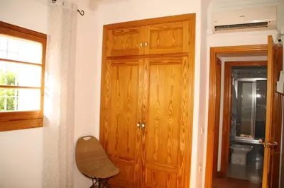 a wooden door in a room with a chair at Studio Sleeps 4 with Terrace in Chipiona