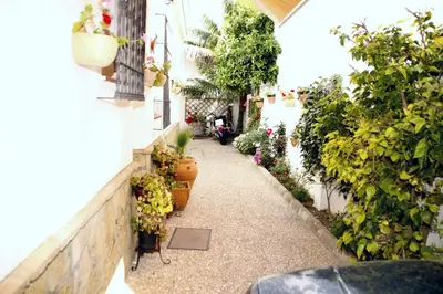 a walkway with potted plants on a building at Studio Sleeps 4 with Terrace in Chipiona