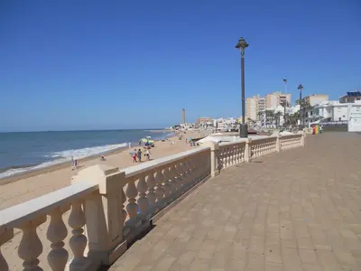 a beach with people on the sand and the ocean at Studio Sleeps 4 with Terrace in Chipiona