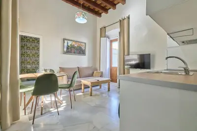 a kitchen and living room with a table and chairs at Refugio de Visitación in Jerez de la Frontera