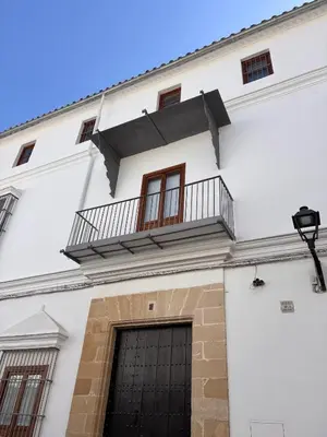 a white building with a balcony on top of it at Refugio de Visitación in Jerez de la Frontera
