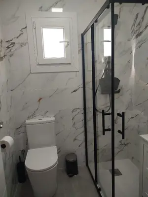 a bathroom with a toilet and a glass shower at Pacifico conil in Cádiz