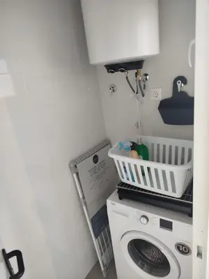 a laundry room with a washing machine and a cabinet at Pacifico conil in Cádiz