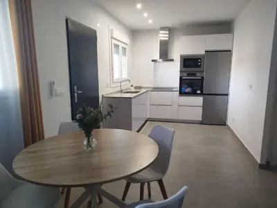 a kitchen with a wooden table and chairs and a kitchen with a table at Pacifico conil in Cádiz