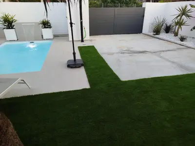 a backyard with a swimming pool and green grass at Pacifico conil in Cádiz