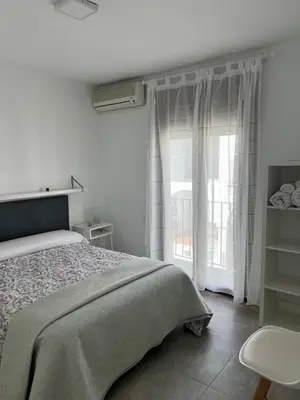 a white bedroom with a bed and a window at Casa Flamenco in El Cuervo