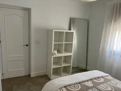 a bedroom with a white book shelf next to a bed at Casa Flamenco in El Cuervo