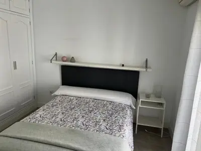 a small bedroom with a bed and a shelf above it at Casa Flamenco in El Cuervo