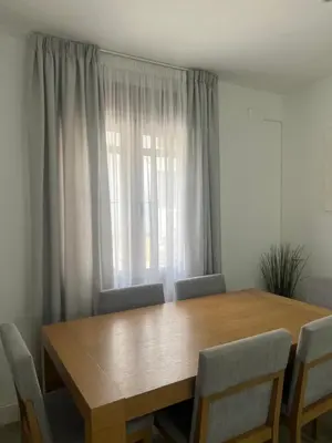 a dining room table with chairs and a window at Casa Flamenco in El Cuervo