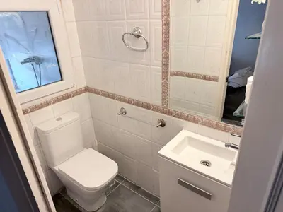 a bathroom with a white toilet and a sink at Mar de Luz Boutique in Novo Sancti Petri