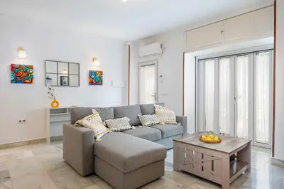 a living room with a couch and a table at Grand Marina Suite - Puerto Sherry in El Puerto de Santa María