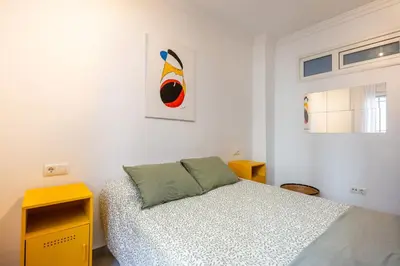 a white bedroom with a bed and a yellow cabinet at Grand Marina Suite - Puerto Sherry in El Puerto de Santa María
