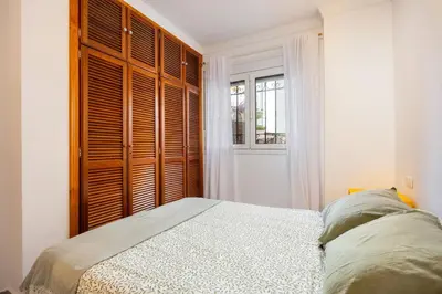 a bedroom with a bed and a large window at Grand Marina Suite - Puerto Sherry in El Puerto de Santa María