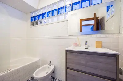 a bathroom with a sink and a toilet and a tub at Grand Marina Suite - Puerto Sherry in El Puerto de Santa María