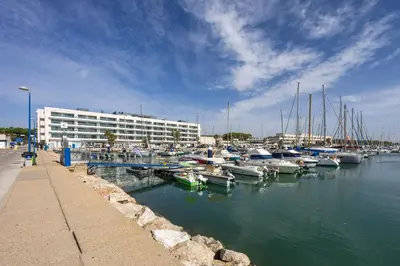 a marina with boats in the water and a building at Grand Marina Suite - Puerto Sherry in El Puerto de Santa María