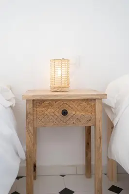 a wooden table with a basket on it next to two beds at Casa Salmedina in Sanlúcar de Barrameda
