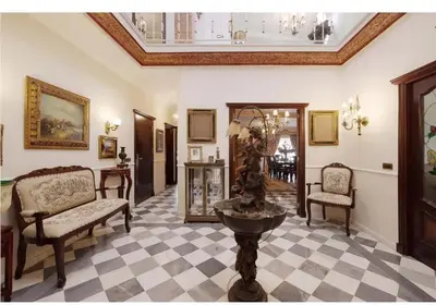 a living room with two chairs and a table at Casa Palacete en el corazón de Cádiz in Paterna de Rivera