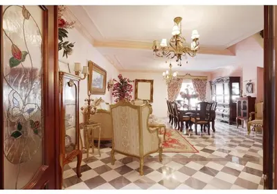 a living room with a chandelier and a dining room at Casa Palacete en el corazón de Cádiz in Paterna de Rivera