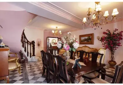 a dining room with a table with flowers on it at Casa Palacete en el corazón de Cádiz in Paterna de Rivera