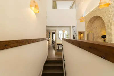 a hallway of a house with white walls and stairs at Musart Entre Artes in Jerez de la Frontera