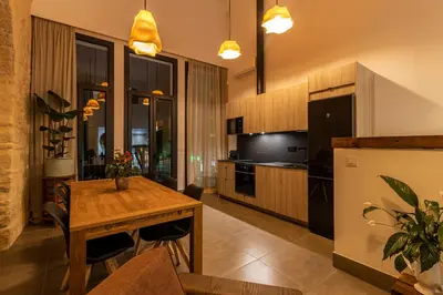 a kitchen and dining room with a wooden table at Musart Entre Artes in Jerez de la Frontera