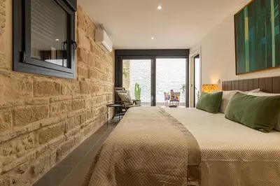 a bedroom with a large bed and a brick wall at Musart Entre Artes in Jerez de la Frontera