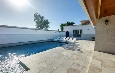 a swimming pool with white chairs next to a house at Lovely Home In San Antoniojerez De L With Wifi in La Barca de la Florida