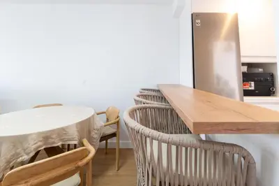 a kitchen with a table and chairs and a refrigerator at Doñana Loft 17 in Sanlúcar de Barrameda