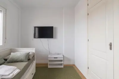a bedroom with a bed and a tv on a wall at Doñana Loft 17 in Sanlúcar de Barrameda