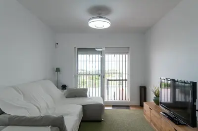 a living room with a white couch and a tv at Doñana Loft 17 in Sanlúcar de Barrameda