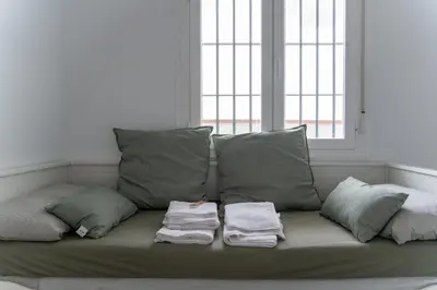 a couch with pillows and towels on it in a room at Doñana Loft 17 in Sanlúcar de Barrameda