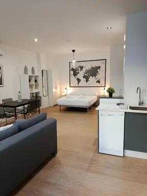 a kitchen and a living room with a couch and a table at Allo Apartments Santa María IV Centro Loft in Jerez de la Frontera
