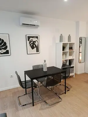 a dining room with a black table and chairs at Allo Apartments Santa María IV Centro Loft in Jerez de la Frontera