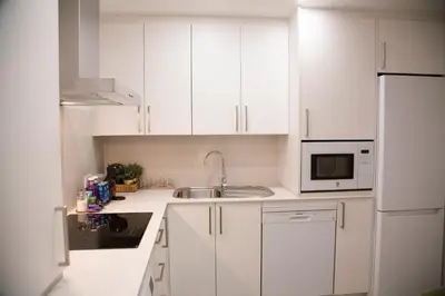 a white kitchen with a sink and a microwave at Hidden Gem GRAN TEATRO FALLA SUITES by ApartmentsinCadiz in Cádiz